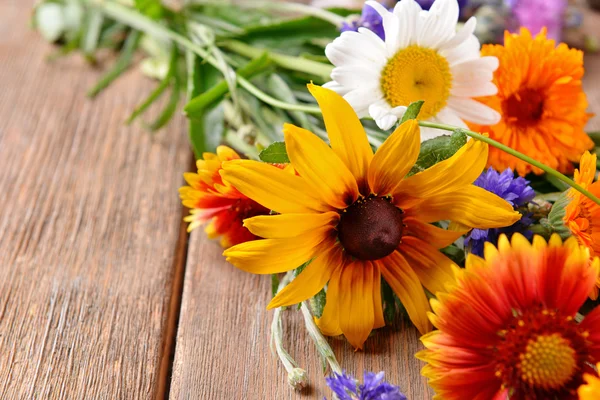 Яркие полевые цветы на деревянном столе, крупный план — стоковое фото