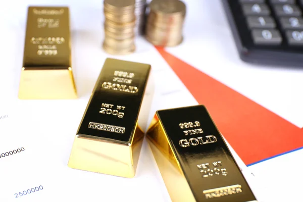 Bullion ouro com moedas em documentos de fundo — Fotografia de Stock