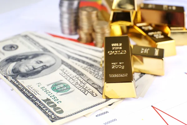 Lingotes de oro con dinero en la mesa —  Fotos de Stock