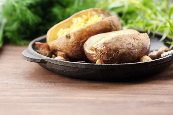 Batatas assadas com queijo e cogumelos na mesa de perto — Fotografia de Stock