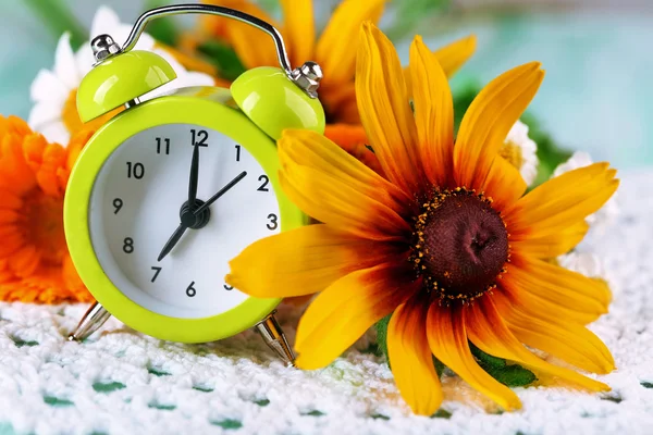 Small alarm clock with beautiful flowers — Stock Photo, Image