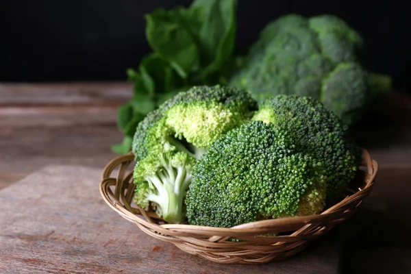 Broccoli freschi in ciotola con spinaci su fondo scuro — Foto Stock