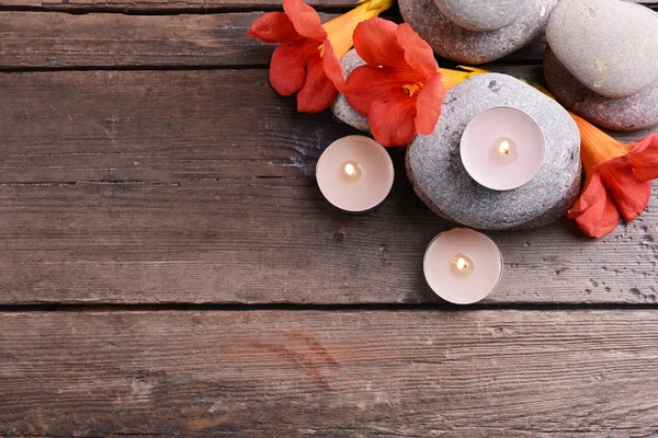 Schöne Wellness-Komposition mit Kerzen und Blumen auf Holztisch in Nahaufnahme — Stockfoto