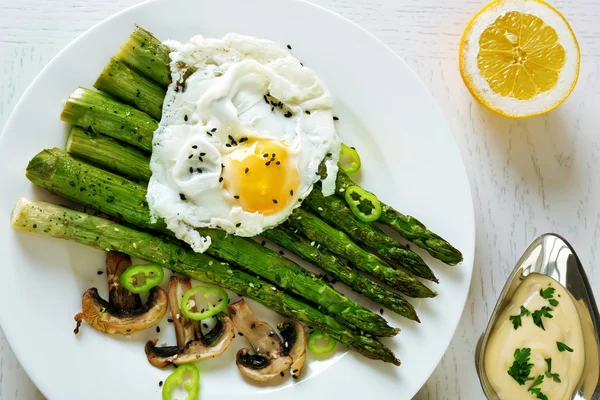 Asparagi arrosto con uovo in camicia su fondo tavola — Foto Stock