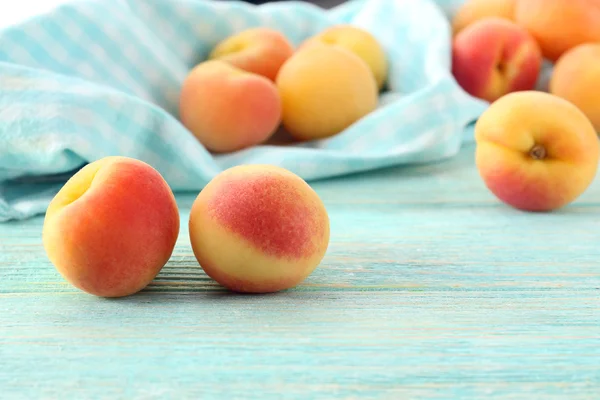 Ripe apricots with napkin on wooden table close up — Stock Photo, Image