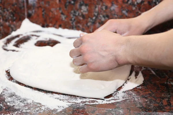 Шеф-повар готовит тесто для пиццы на мраморном столе, крупным планом — стоковое фото