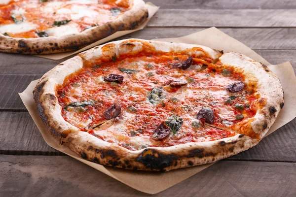 Delicious pizzas on wooden table, closeup — Stock Photo, Image