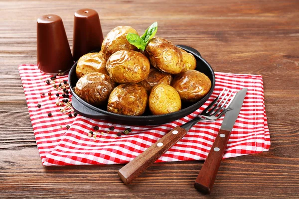 Gebakken aardappelen in pan op houten tafel, close-up — Stockfoto