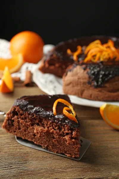 Cake with Chocolate Glaze and orange on plate, on wooden table, on dark  background — Stock Photo, Image