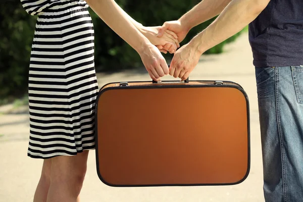 Young couple holding vintage suitcase — Stock Photo, Image