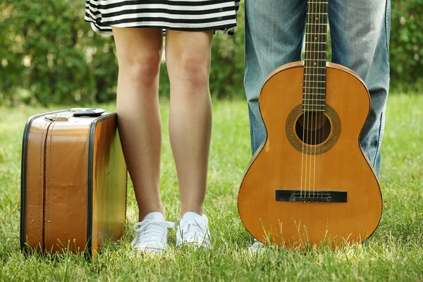 Молодая пара с чемоданом и гитарой — стоковое фото