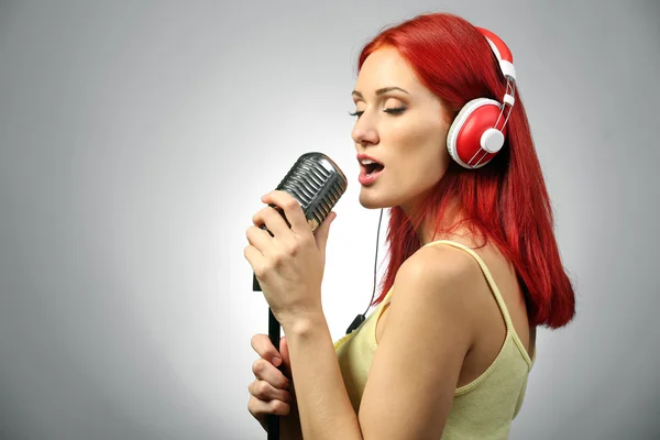 Güzel genç kadının mikrofonla şarkı — Stok fotoğraf