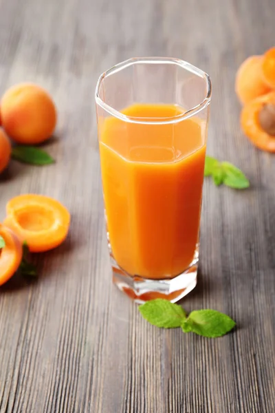 Glass of apricot juice and fresh fruits on table close up — Stock Photo, Image