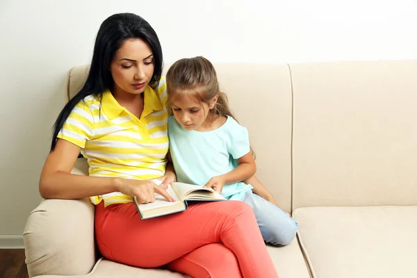 Flicka läsa bok med mamma — Stockfoto