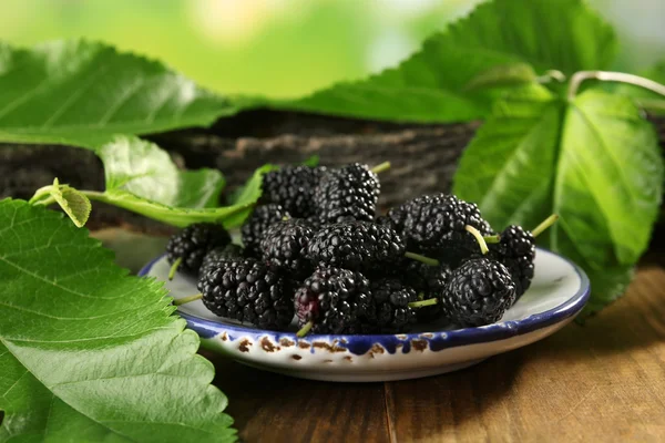 Moras maduras con hojas verdes en la mesa de cerca — Foto de Stock