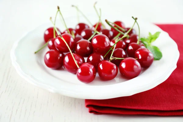 Sweet cherries on plate, on light background — Stock Photo, Image