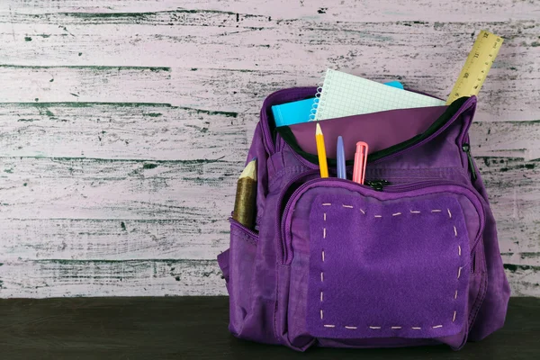 Mochila escolar sobre fondo de madera — Foto de Stock