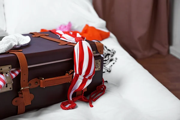 Valise avec vêtements sur le lit — Photo