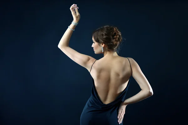 Pretty woman with bare back on dark background — Stock Photo, Image