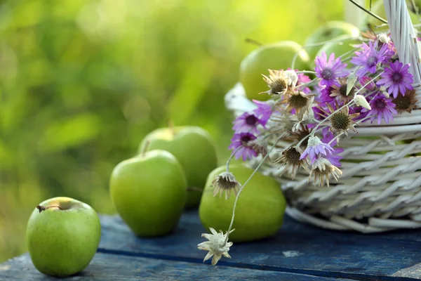 Maçãs verdes com buquê de flores silvestres — Fotografia de Stock