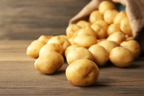 Papas nuevas sobre fondo de madera — Foto de Stock