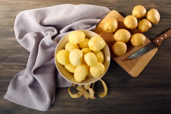 Obrane ziemniaki nowy w misce na drewnianym stole z serwetka, widok z góry — Zdjęcie stockowe