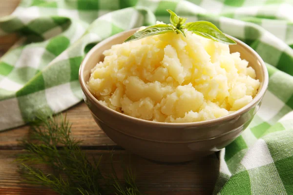 Purê de batatas em tigela na mesa de madeira com guardanapo xadrez, close-up — Fotografia de Stock