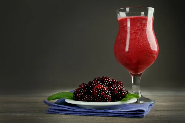 Glas blackberry smoothie på träbord på grå bakgrund — Stockfoto