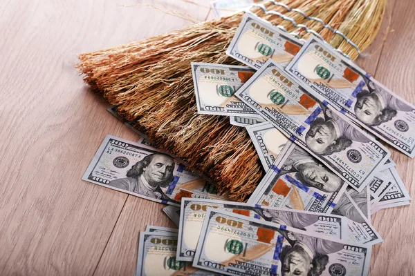Dollars en bezem op houten vloer — Stockfoto