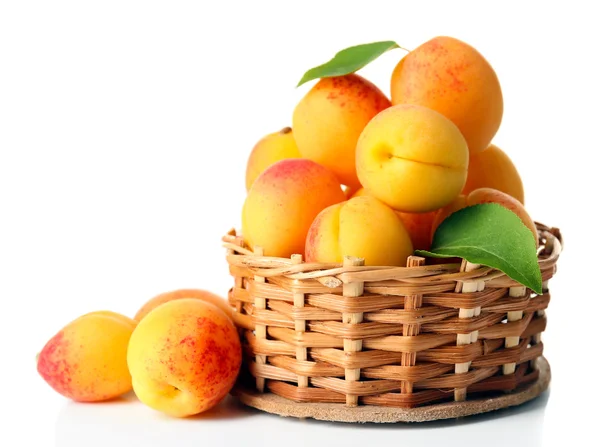 Abricots mûrs dans un bol en osier isolé sur blanc — Photo