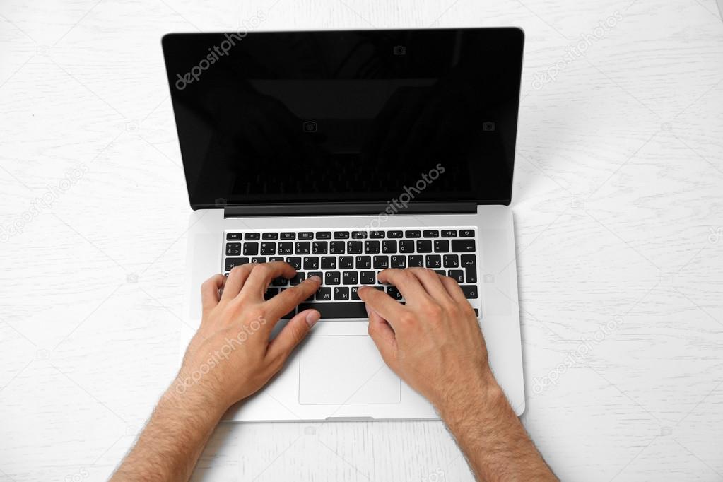 Man hand on laptop on table top view