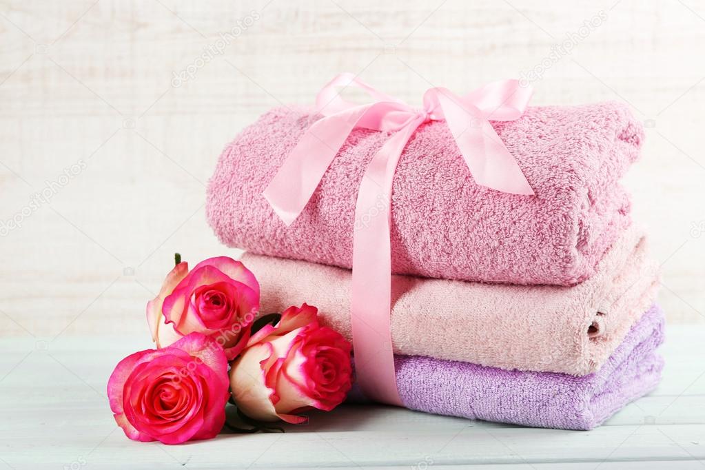 Stack of colorful towels on light wooden background