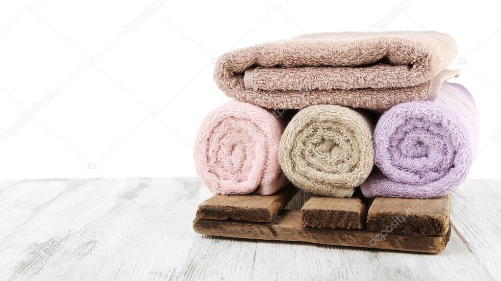 Rolled bath towels on wooden table