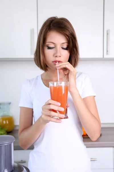 Молодая красивая женщина пьет яблочный сок — стоковое фото