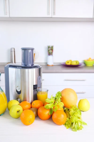 Juicer e frutas na mesa — Fotografia de Stock