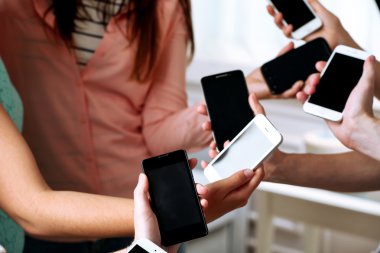 Birçok el cep telefonlarını yakın tutuyor.