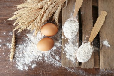 Buğday ve ahşap masa, closeup üzerinde yumurta ile bütün un