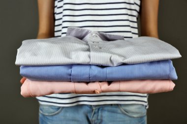 Gömlek gri arka plan üzerinde tutan kadın