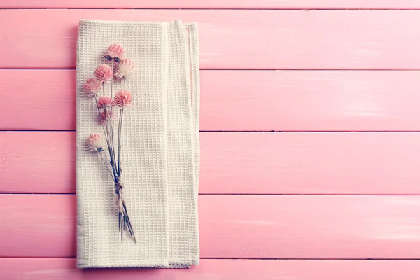 Schöne trockene Blumen auf Serviette auf Holzgrund — Stockfoto