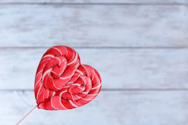 Lollipop brillante en forma de corazón sobre fondo de madera —  Fotos de Stock