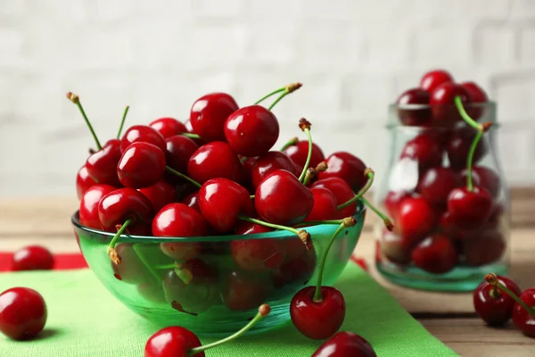 Cerejas doces em tigela na mesa de perto — Fotografia de Stock