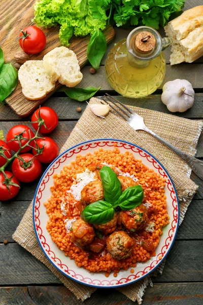 Balletjes met linzen en tomaten saus, houten lepel op houten achtergrond — Stockfoto