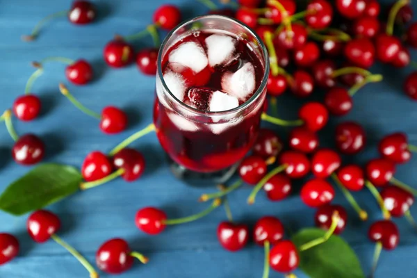 Glass of fresh juice with cherries on wooden table close up — Stock Photo, Image