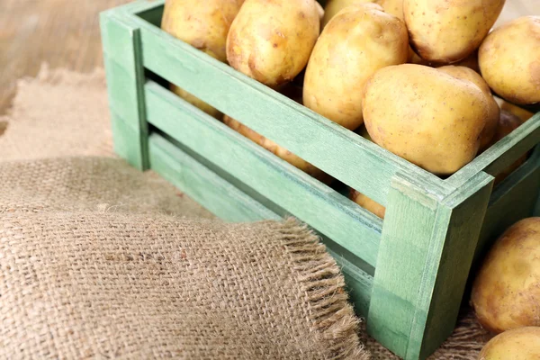 Jeunes pommes de terre en caisse sur la table fermer — Photo