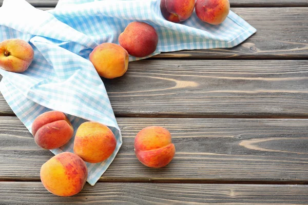 Söta mogna persikor på bordet på nära håll — Stockfoto