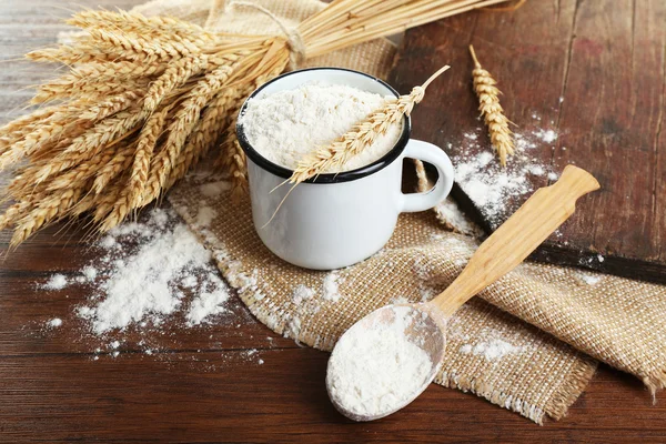 Whole flour with wheat on wooden table, closeup — Stock Photo, Image