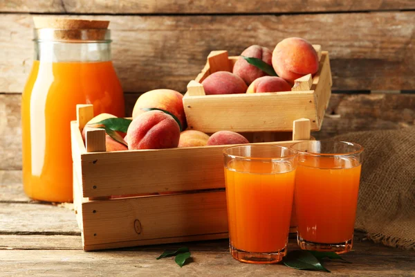 Mogna persikor och juice på trä bakgrund — Stockfoto