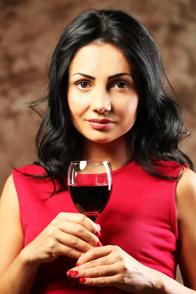 茶色の背景にワイングラスを持つかなり若い女性 — ストック写真