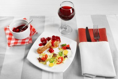 Kadeh şarap peçete, closeup tablo ile beyaz tabak içinde pişmiş tavuk bacak ve sebze salatası fincan