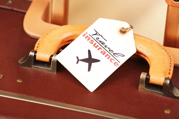 Suitcase with TRAVEL INSURANCE label, closeup — Stock Photo, Image
